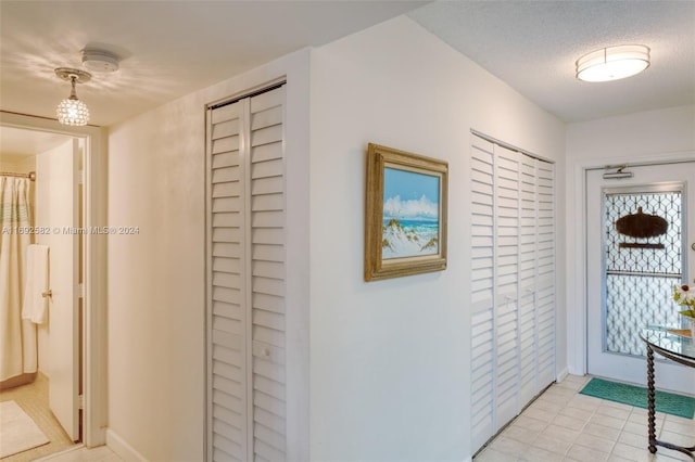 interior space with a textured ceiling and light tile patterned flooring