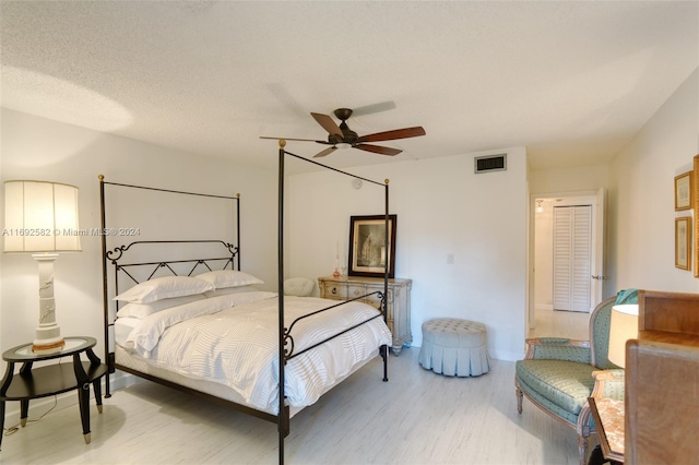 bedroom featuring wood-type flooring, ceiling fan, and a textured ceiling