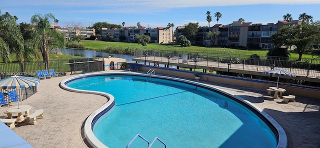 view of pool with a patio and a water view