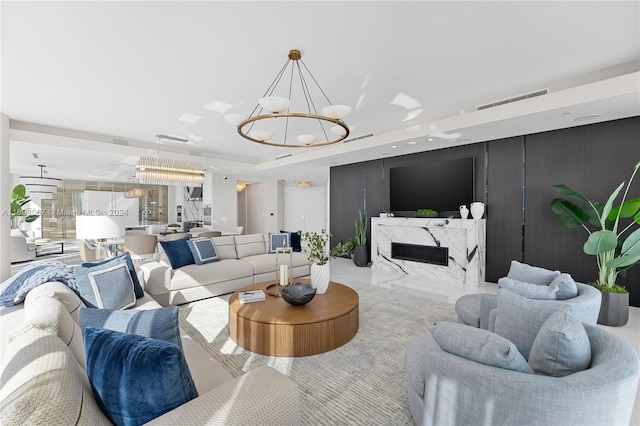 living room with an inviting chandelier and a high end fireplace