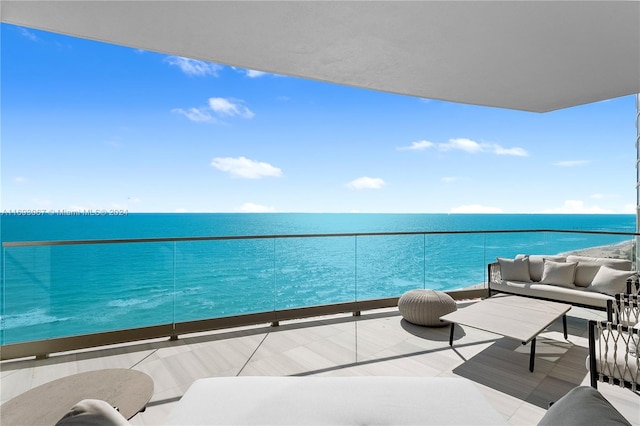 balcony with a water view and an outdoor living space