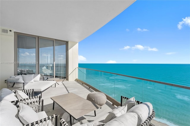 balcony with an outdoor living space and a water view