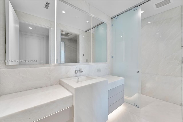 bathroom with tile walls, tiled shower, and vanity