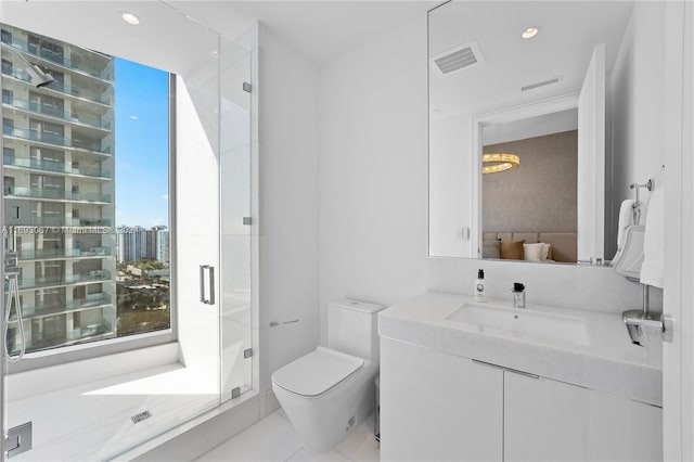 bathroom with a shower with shower door, vanity, and toilet