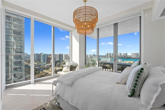 bedroom featuring access to exterior, hardwood / wood-style floors, multiple windows, and floor to ceiling windows