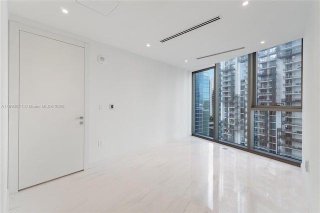 spare room with floor to ceiling windows and plenty of natural light