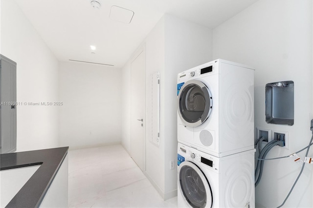 laundry area featuring stacked washer and dryer and sink