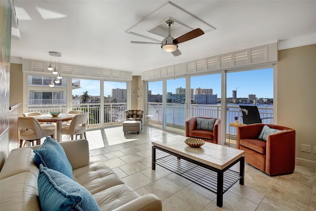 sunroom / solarium with ceiling fan and a water view