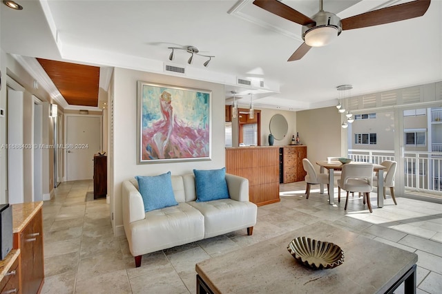 living room featuring ceiling fan and crown molding