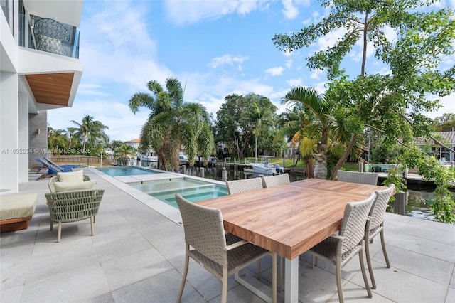 view of swimming pool with a patio and a water view