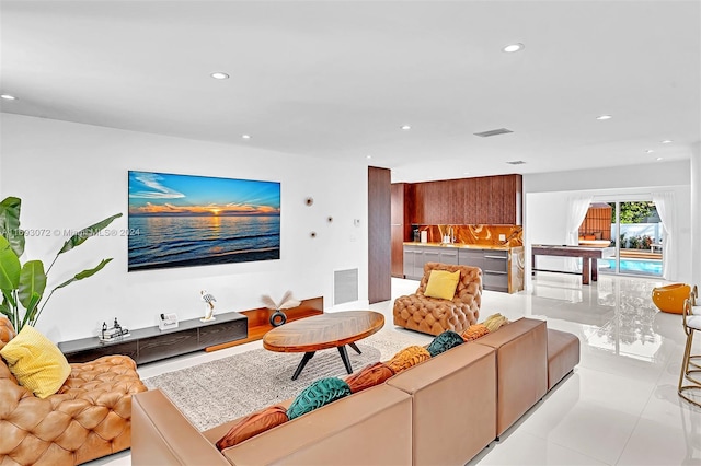 living room featuring sink and light tile patterned floors