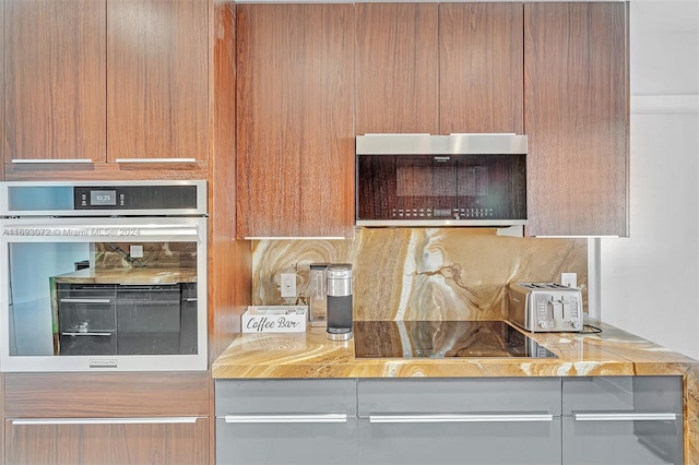 kitchen with appliances with stainless steel finishes and light stone counters