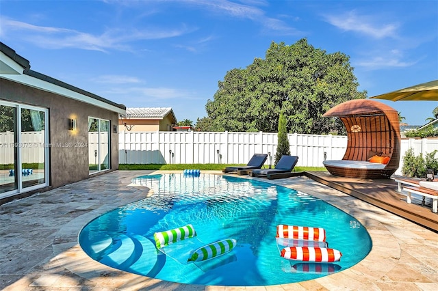 view of swimming pool with a wooden deck and a patio