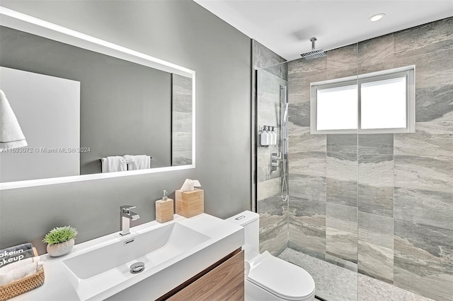 bathroom featuring vanity, toilet, and a tile shower