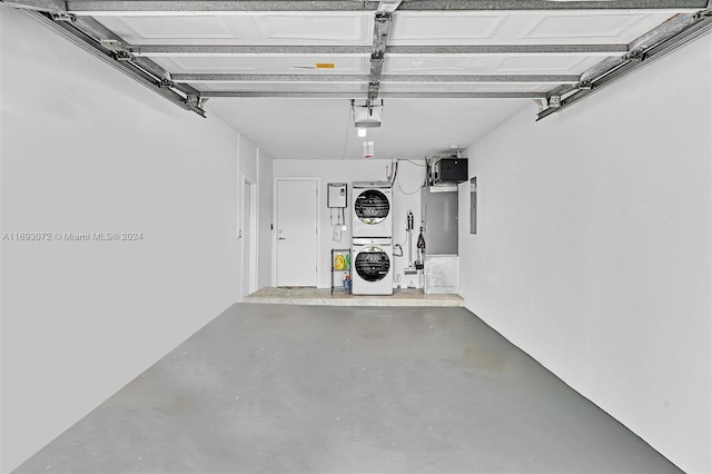 garage featuring stacked washer and dryer and a garage door opener