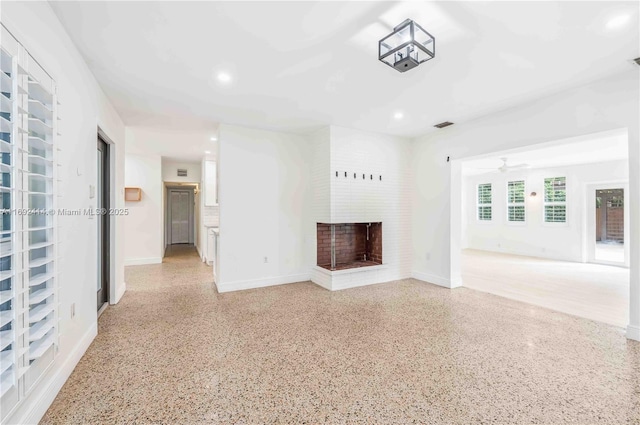 unfurnished living room featuring ceiling fan and a fireplace