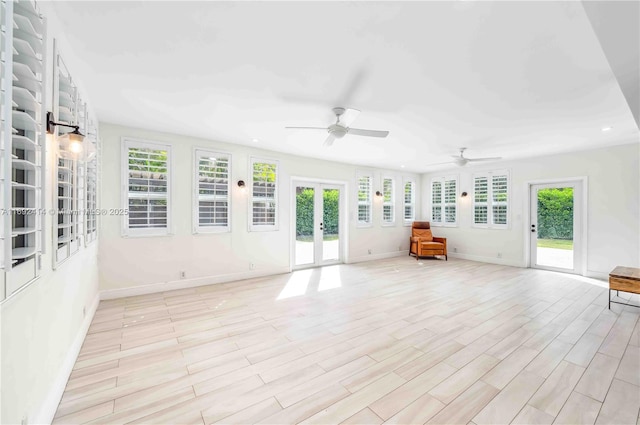 unfurnished living room with light wood-type flooring, ceiling fan, and a healthy amount of sunlight