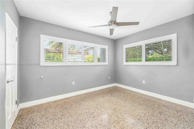 spare room featuring ceiling fan and a healthy amount of sunlight