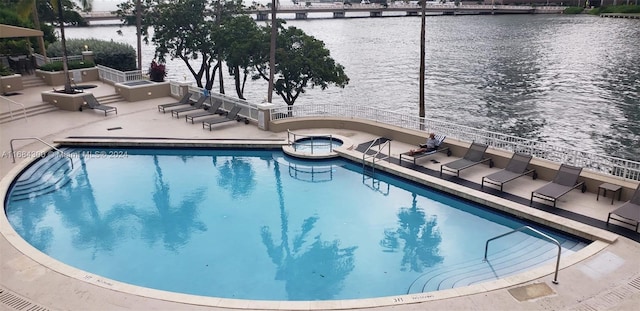 view of swimming pool with a patio and a water view