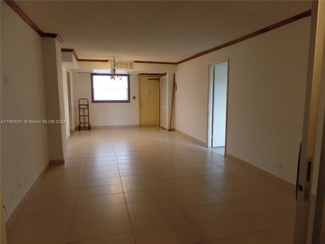 tiled spare room with crown molding