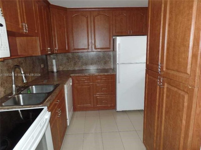 kitchen with backsplash, sink, light tile patterned floors, and white appliances