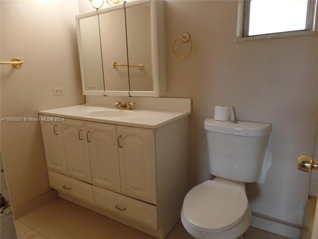 bathroom featuring tile patterned flooring, vanity, and toilet