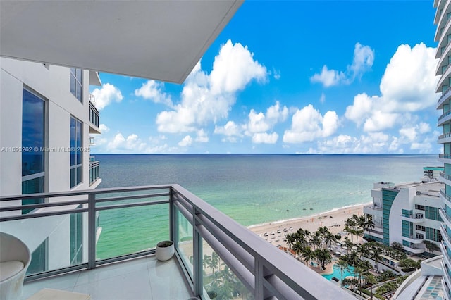 balcony featuring a view of the beach and a water view