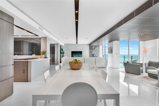 dining area with floor to ceiling windows, light tile patterned flooring, a fireplace, and visible vents