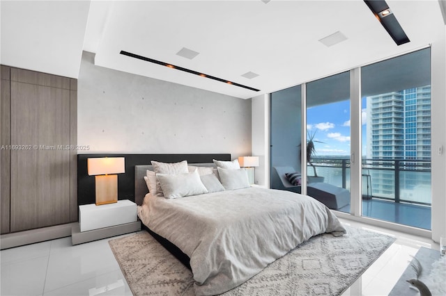 bedroom with expansive windows, access to outside, and light tile patterned floors