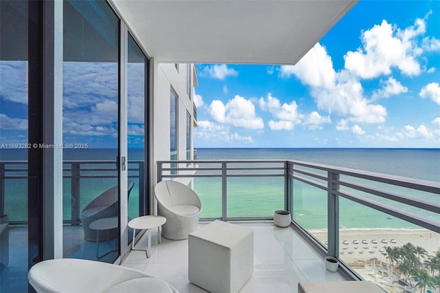 balcony with a water view and a view of the beach