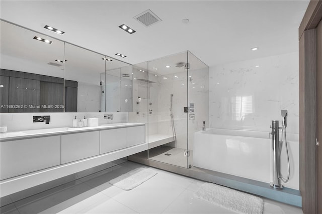 bathroom featuring a sink, visible vents, a tub, double vanity, and a stall shower