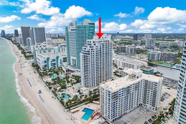 drone / aerial view featuring a view of the beach, a water view, and a view of city