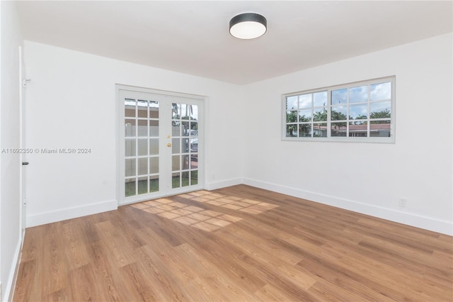 spare room featuring plenty of natural light, light hardwood / wood-style floors, and french doors