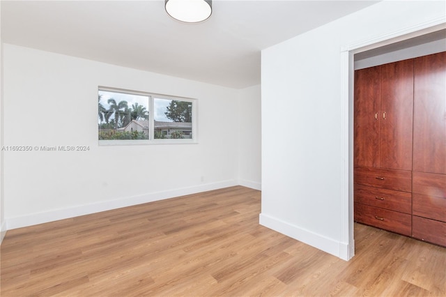 unfurnished bedroom featuring light wood-type flooring and a closet