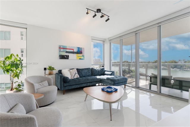 living room featuring a wall of windows and a water view