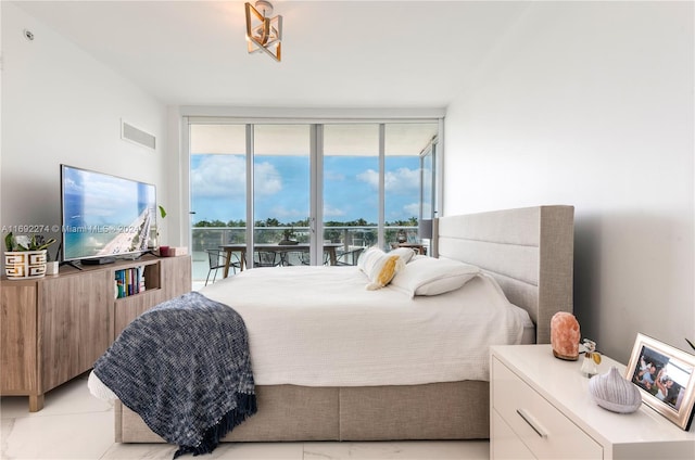 bedroom with a wall of windows and access to exterior