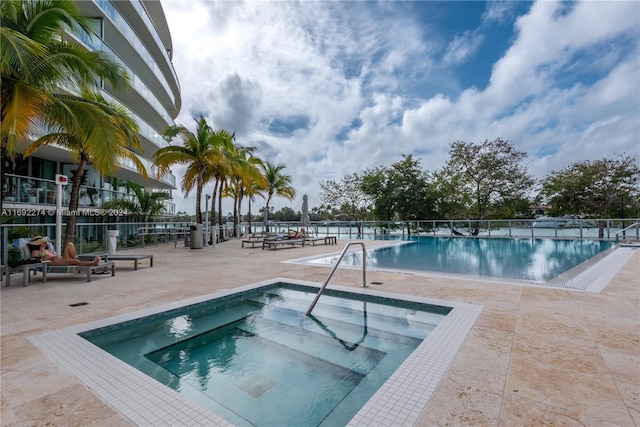 view of pool featuring a hot tub and a patio area