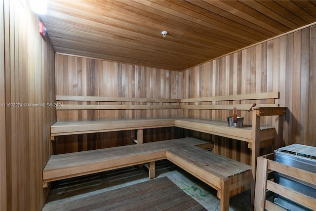 view of sauna with wooden ceiling and wooden walls