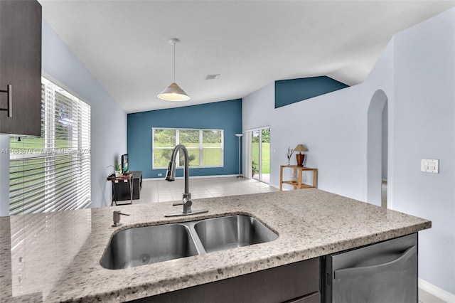 kitchen with sink, light stone counters, stainless steel dishwasher, pendant lighting, and lofted ceiling