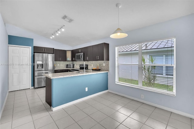 kitchen featuring kitchen peninsula, decorative backsplash, dark brown cabinets, stainless steel appliances, and lofted ceiling