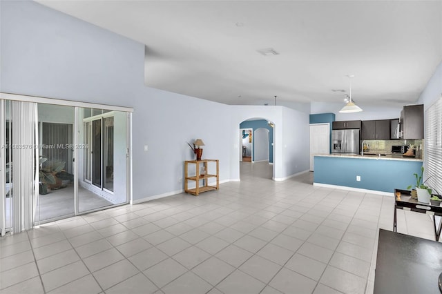 unfurnished living room with light tile patterned floors and sink