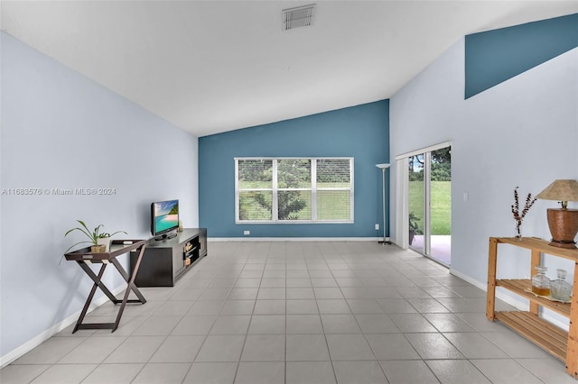 living room with light tile patterned floors, vaulted ceiling, and plenty of natural light