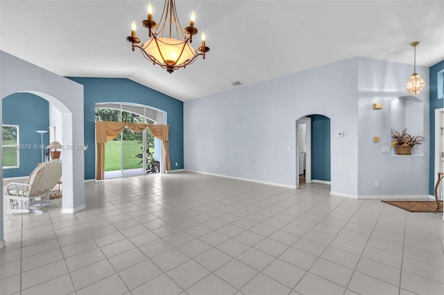 spare room featuring a notable chandelier, light tile patterned flooring, and vaulted ceiling