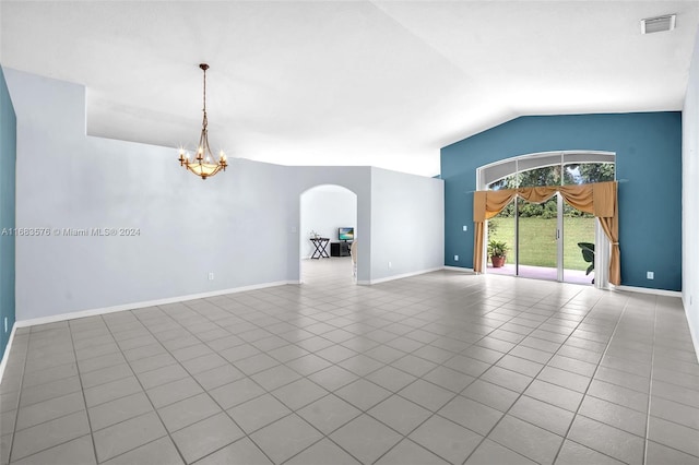 empty room featuring tile patterned flooring, a chandelier, and vaulted ceiling