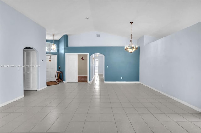 unfurnished room featuring light tile patterned floors, lofted ceiling, and a notable chandelier