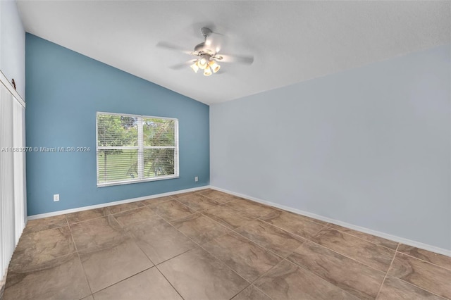 empty room featuring ceiling fan, tile patterned flooring, and vaulted ceiling