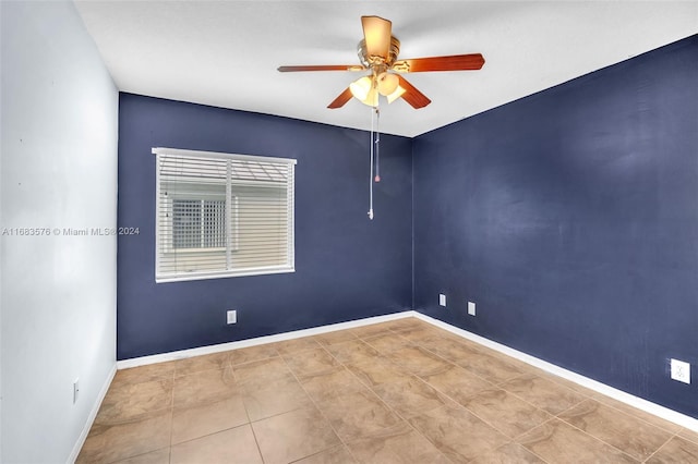 tiled spare room with ceiling fan