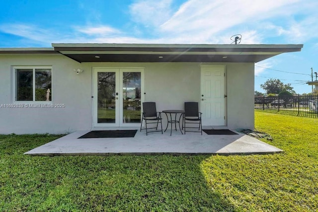 back of property with french doors, a yard, and a patio