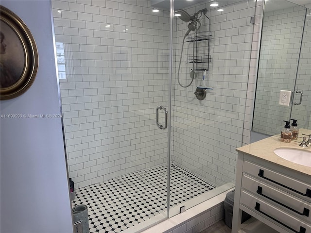 bathroom with toilet, vanity, and a shower with shower door