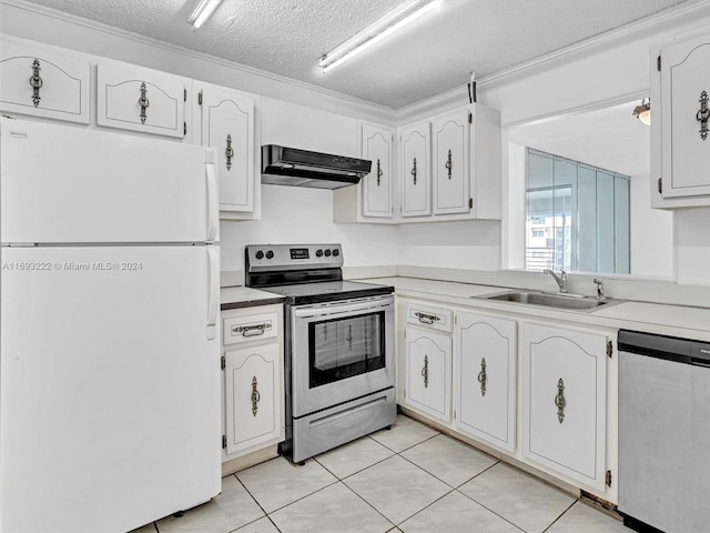 kitchen with sink, appliances with stainless steel finishes, a textured ceiling, light tile patterned floors, and white cabinets